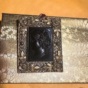 A Czech black glass cameo in gilt brass filigree pin brooch from the 1920s.